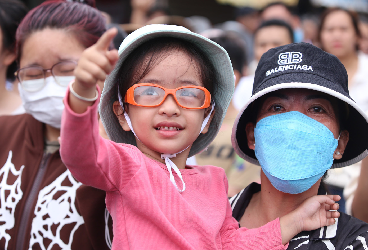 Em bé hào hứng theo dõi mọi người chinh phục cột mỡ trơn tuột.