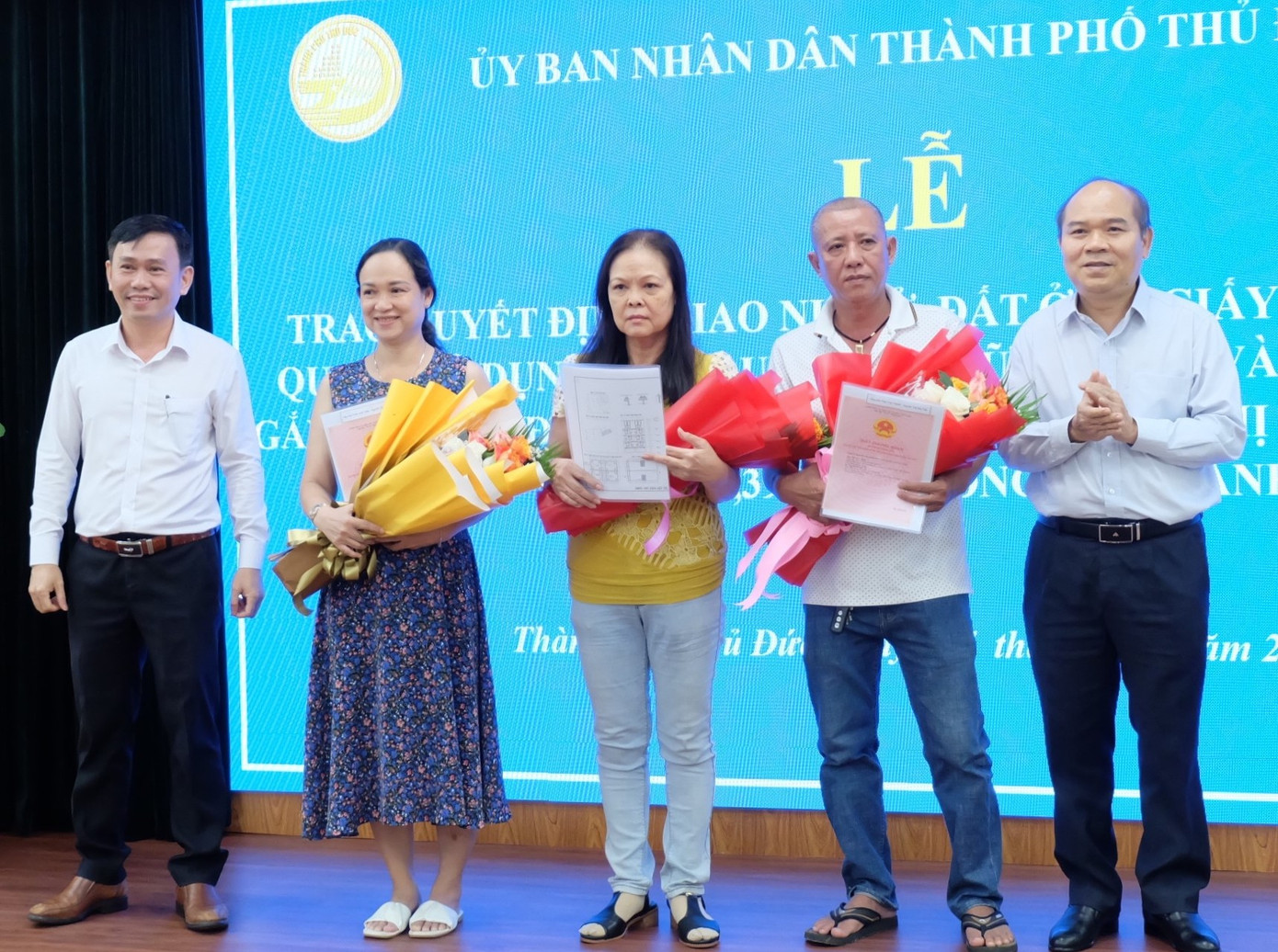 Lãnh đạo UBND TP. Thủ Đức, Sở Tài nguyên và Môi trường TPHCM trao quyết định bố trí tái định cư, Giấy chứng nhận quyền sử dụng đất... cho người dân Khu đô thị mới Thủ Thiêm. Ảnh: Thu Hường.