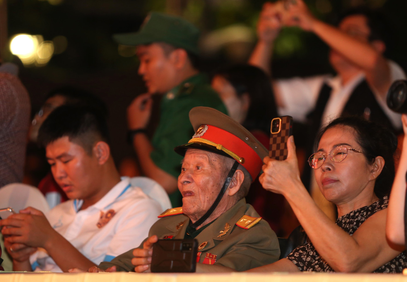 Người cựu binh già chăm chú theo dõi những tiết mục nghệ thuật tái hiện lịch sử đấu tranh hào hùng của dân tộc trên sân khấu.