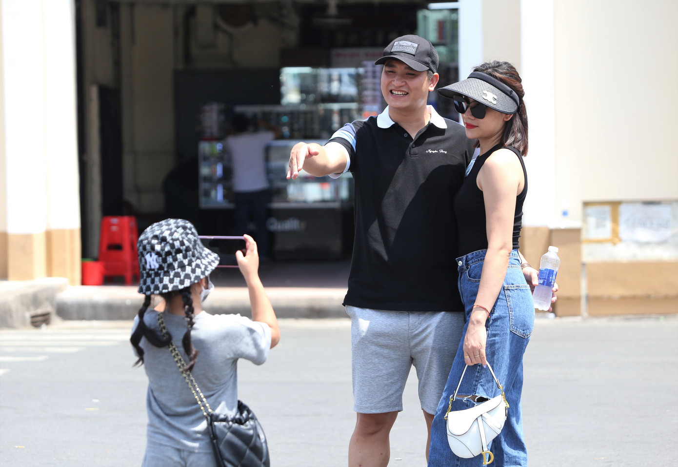 Em bé chụp ảnh cho ba mẹ trước thắng cảnh nổi tiếng.