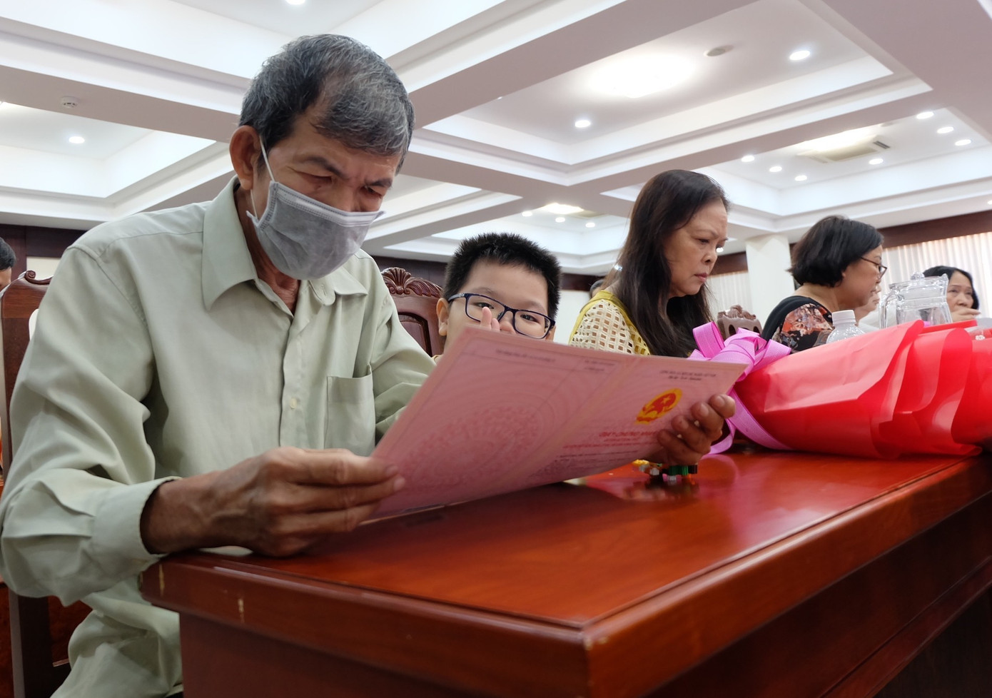 Bà con đón nhận Giấy chứng nhận quyền sử dụng đất, quyền sở hữu nhà ở và các tài sản gắn liền với đất tại buổi lễ.