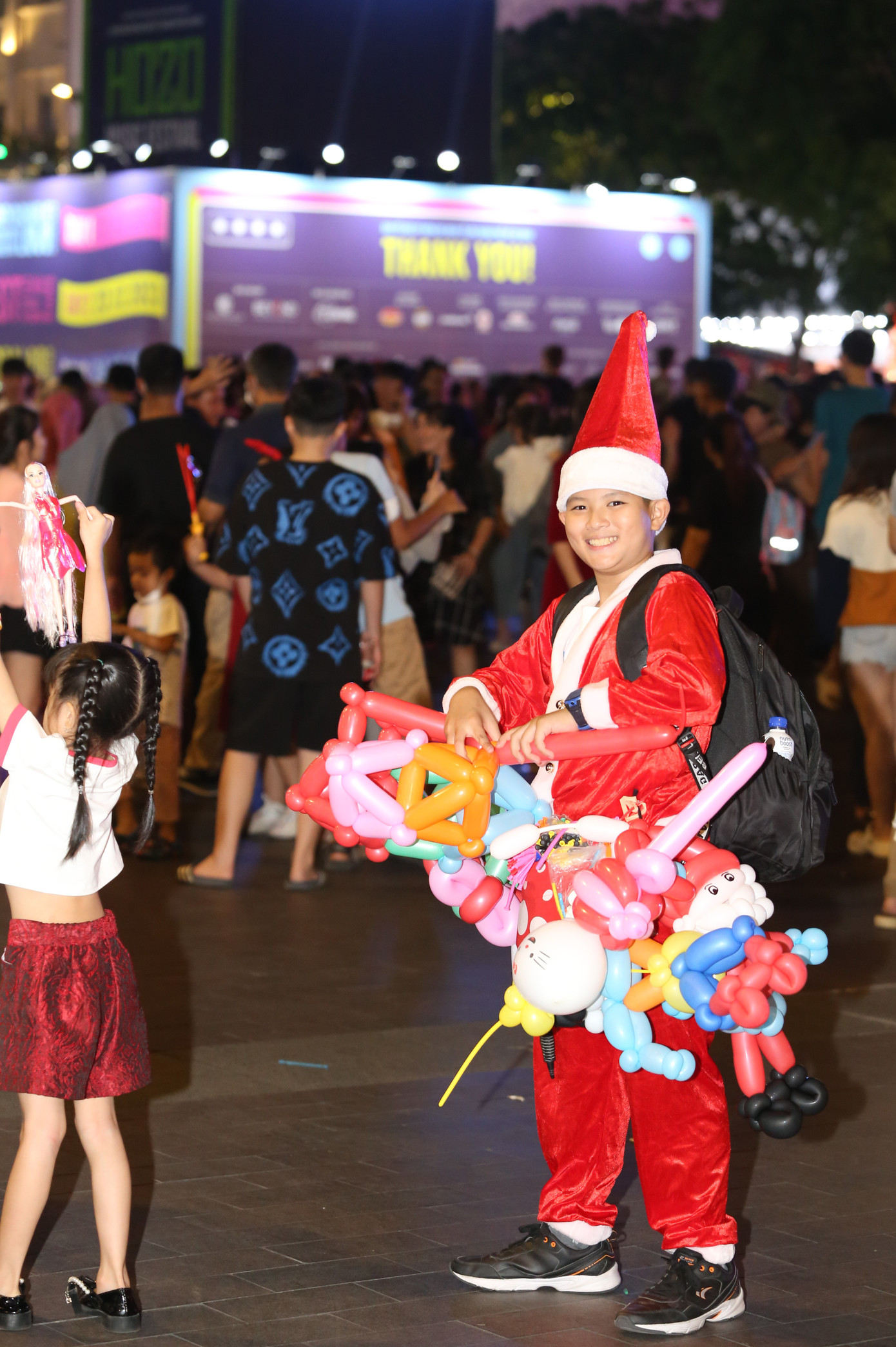 Cậu bé nở nụ cười tươi tắn trước ống kính phóng viên trong lúc đang làm bong bóng nghệ thuật trên phố đi bộ. Cậu bé nở nụ cười tươi tắn trước ống kính phóng viên trong lúc đang làm bong bóng nghệ thuật trên phố đi bộ.