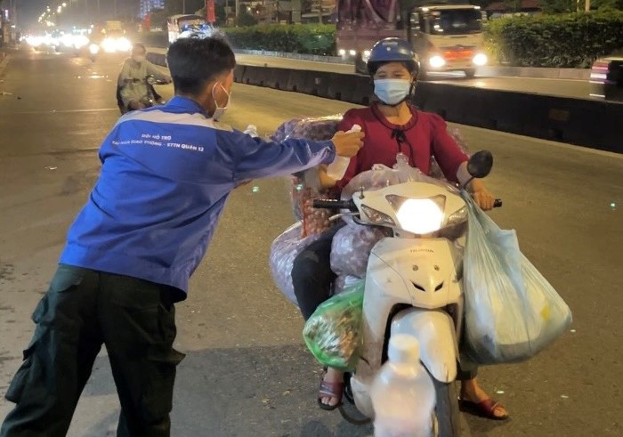 Các bạn gửi tặng phần nước uống đến tay người dân đi đường.