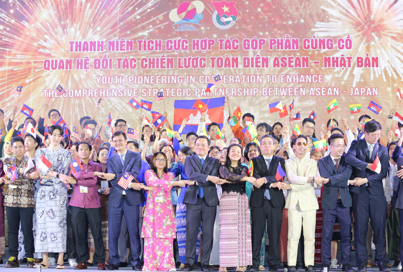 Phó thủ tướng Trần Lưu Quang, Bí thư thứ nhất Trung ương Đoàn Bùi Quang Huy cùng lãnh đạo TPHCM và các bạn đại biểu thanh niên nắm chặt tay trong tình hữu nghị trên nền bài hát "Heal the World".