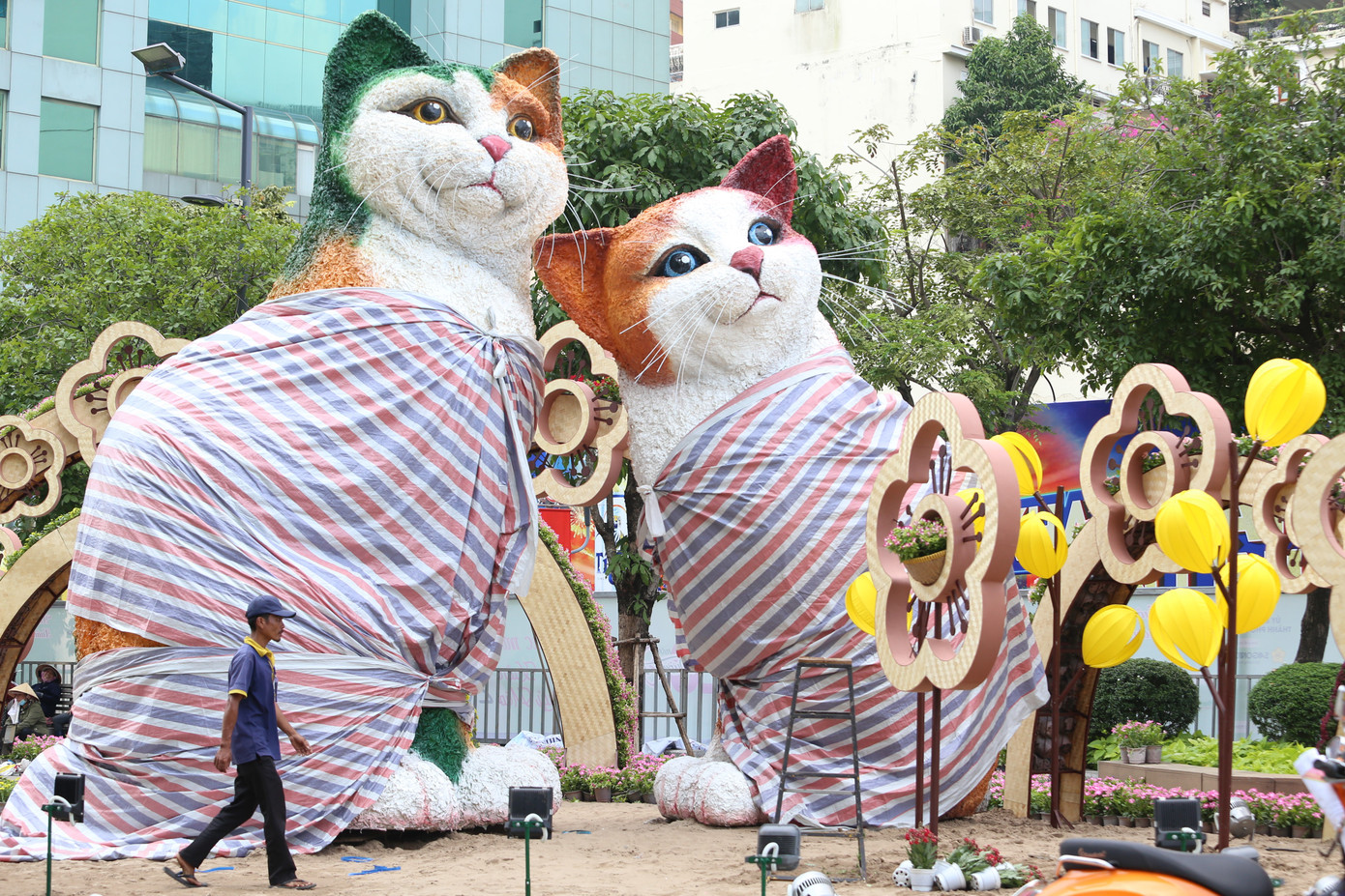 Luôn là điểm nhấn được mọi người chờ đón, linh vật mèo của Đường hoa Nguyễn Huệ năm nay đã lộ diện. Đôi mèo với kích thước cao lớn đã được đặt ở khu vực cổng vào. Từ rất sớm, nhiều người dân TPHCM đã đến đây check in, chiêm ngưỡng và chụp hình cùng hai chú mèo dễ thương này.