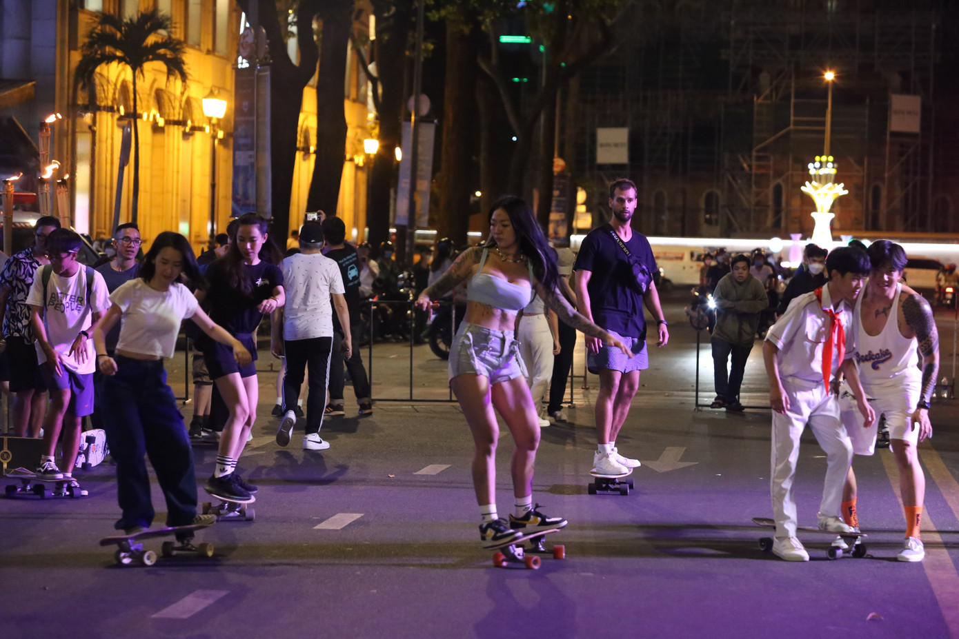 Nhóm bạn trẻ và du khách trải nghiệm bộ môn lướt ván trên đường Phạm Ngọc Thạch.