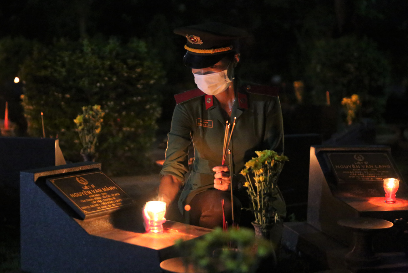Nữ chiến sĩ công an thắp nén hương bên mộ phần liệt sĩ.