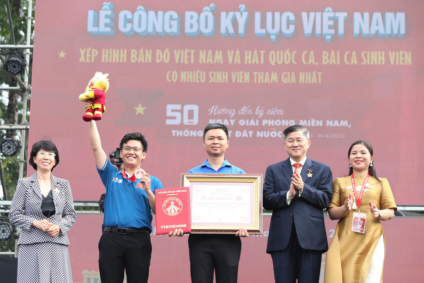 Đại diện Đoàn Thanh niên, Hội Sinh viên trường ĐHSP Kỹ thuật TPHCM nhận bằng ghi nhận Kỷ lục Việt Nam ngay sau màn đồng diễn. "Hoạt động đồng diễn của hơn 5.000 bạn sinh viên, đoàn viên nhà trường đã tạo nên điểm nhấn, dấu ấn chào mừng 50 năm ngày Giải phóng miền Nam, thống nhất đất nước, đồng thời khẳng định vai trò, tinh thần tự hào, yêu nước của con người Việt Nam, của sinh viên Việt Nam với Tổ quốc" - anh Lê Xuân Thân (giữa), Bí thư Đoàn trường khẳng định.