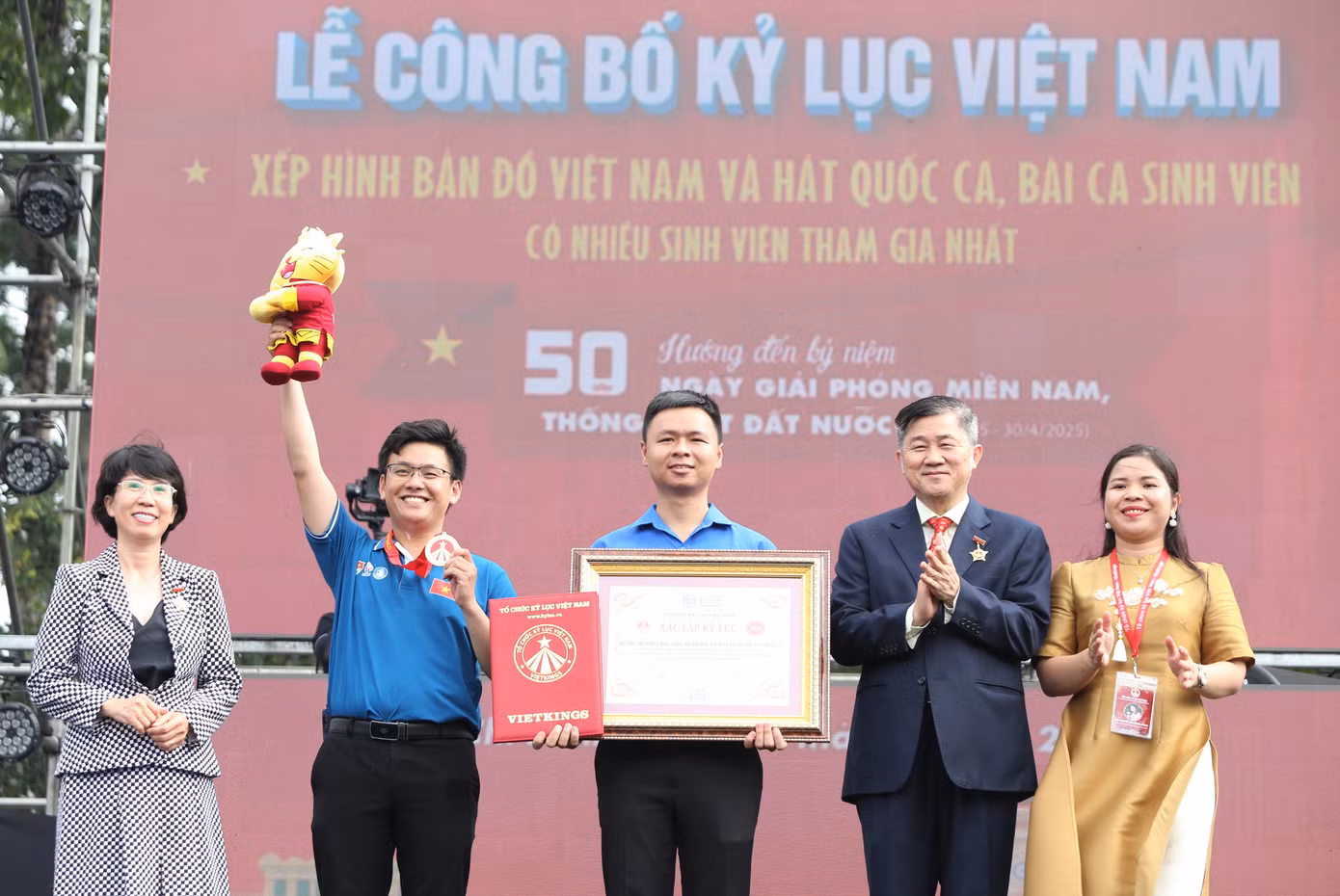 Đại diện Đoàn Thanh niên, Hội Sinh viên trường ĐHSP Kỹ thuật TPHCM nhận bằng ghi nhận Kỷ lục Việt Nam ngay sau màn đồng diễn. "Hoạt động đồng diễn của hơn 5.000 bạn sinh viên, đoàn viên nhà trường đã tạo nên điểm nhấn, dấu ấn chào mừng 50 năm ngày Giải phóng miền Nam, thống nhất đất nước, đồng thời khẳng định vai trò, tinh thần tự hào, yêu nước của con người Việt Nam, của sinh viên Việt Nam với Tổ quốc" - anh Lê Xuân Thân (giữa), Bí thư Đoàn trường khẳng định. Đại diện Đoàn Thanh niên, Hội Sinh viên trường ĐHSP Kỹ thuật TPHCM nhận bằng ghi nhận Kỷ lục Việt Nam ngay sau màn đồng diễn. "Hoạt động đồng diễn của hơn 5.000 bạn sinh viên, đoàn viên nhà trường đã tạo nên điểm nhấn, dấu ấn chào mừng 50 năm ngày Giải phóng miền Nam, thống nhất đất nước, đồng thời khẳng định vai trò, tinh thần tự hào, yêu nước của con người Việt Nam, của sinh viên Việt Nam với Tổ quốc" - anh Lê Xuân Thân (giữa), Bí thư Đoàn trường khẳng định.