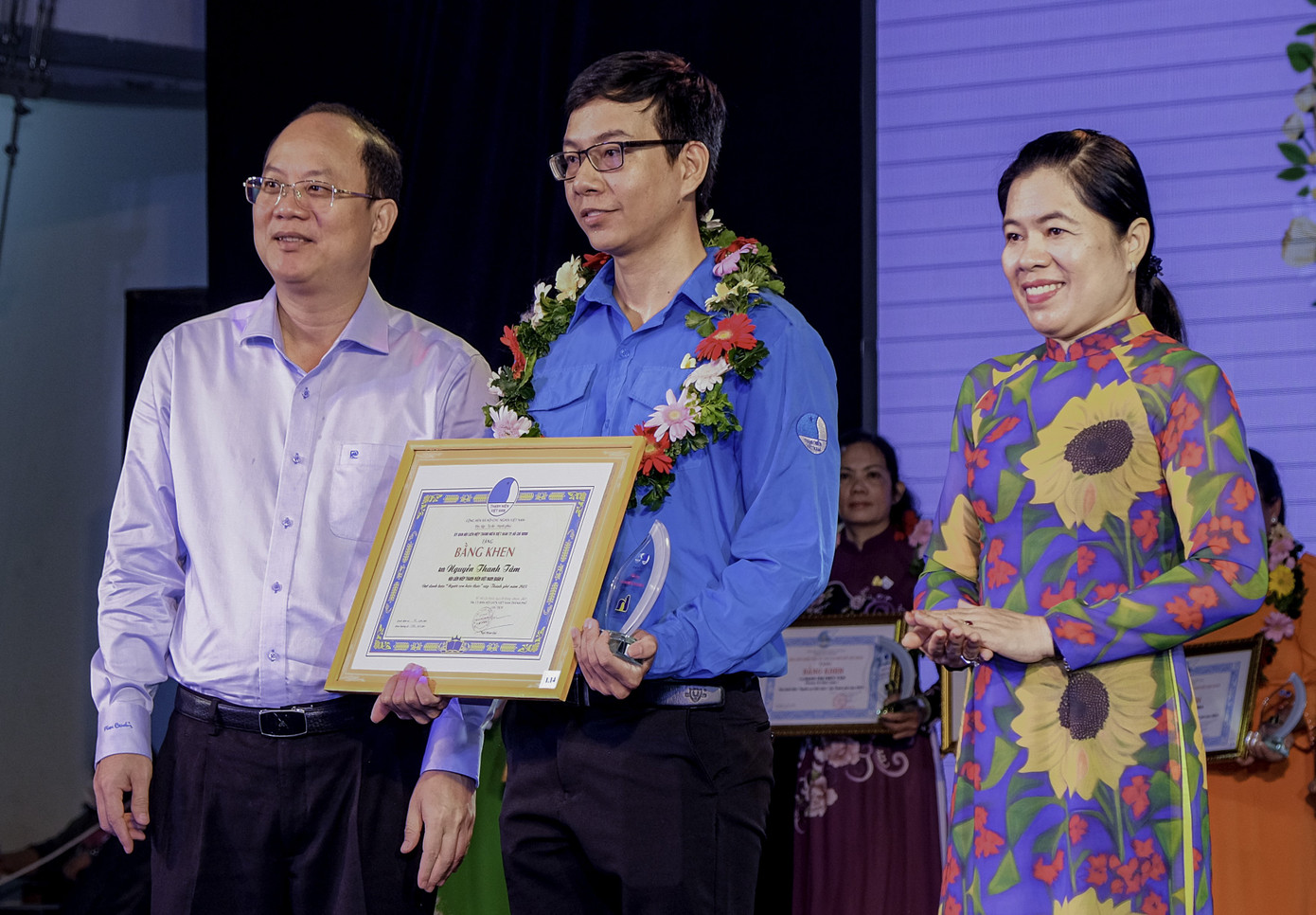 Phó Bí thư Thành uỷ TPHCM Nguyễn Hồ Hải (bìa trái) và Chủ tịch Hội LHPN TPHCM Nguyễn Trần Phượng Trân trao bằng khen tuyên dương anh Nguyễn Thanh Tâm.