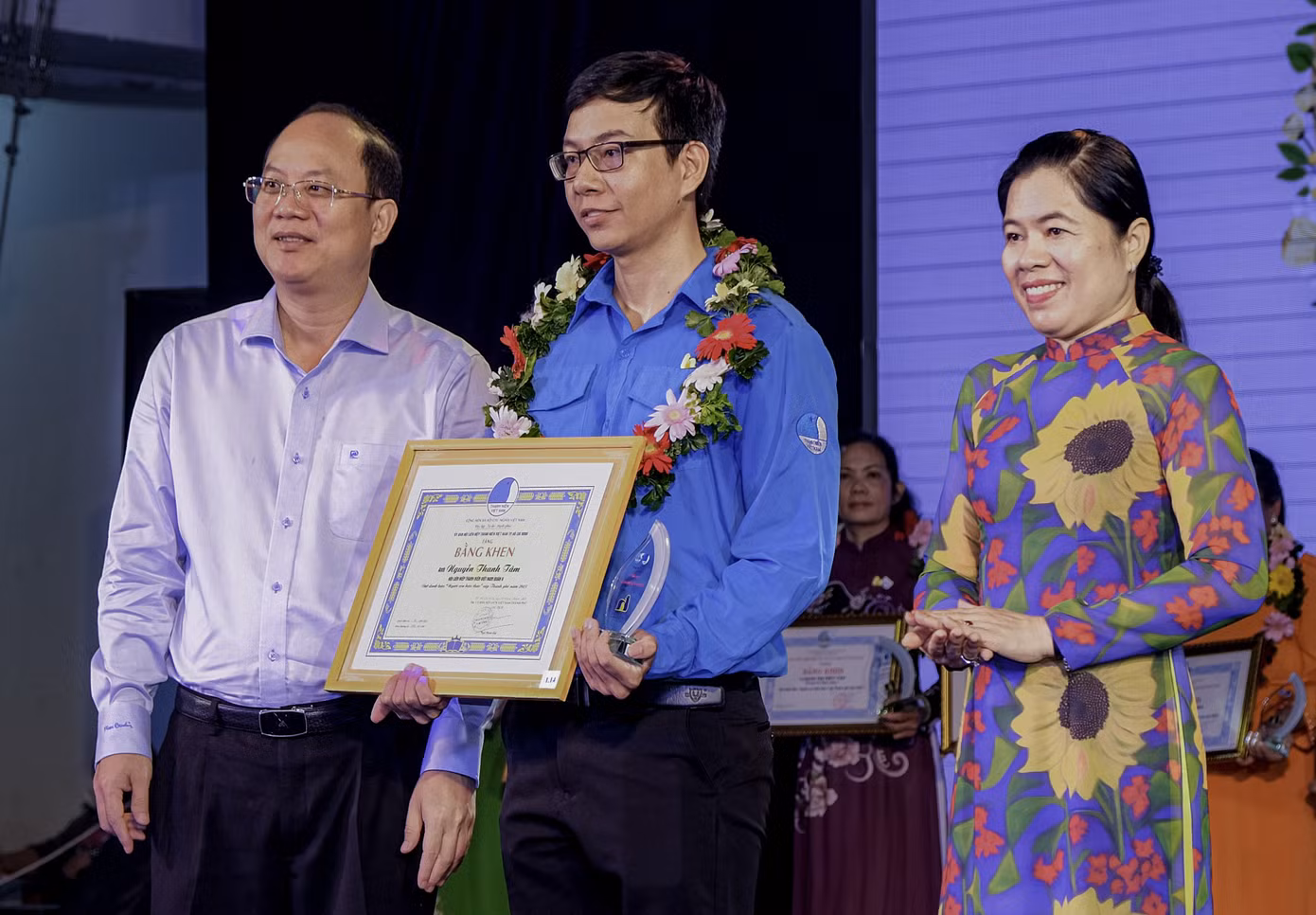 Phó Bí thư Thành uỷ TPHCM Nguyễn Hồ Hải (bìa trái) và Chủ tịch Hội LHPN TPHCM Nguyễn Trần Phượng Trân trao bằng khen tuyên dương anh Nguyễn Thanh Tâm.
