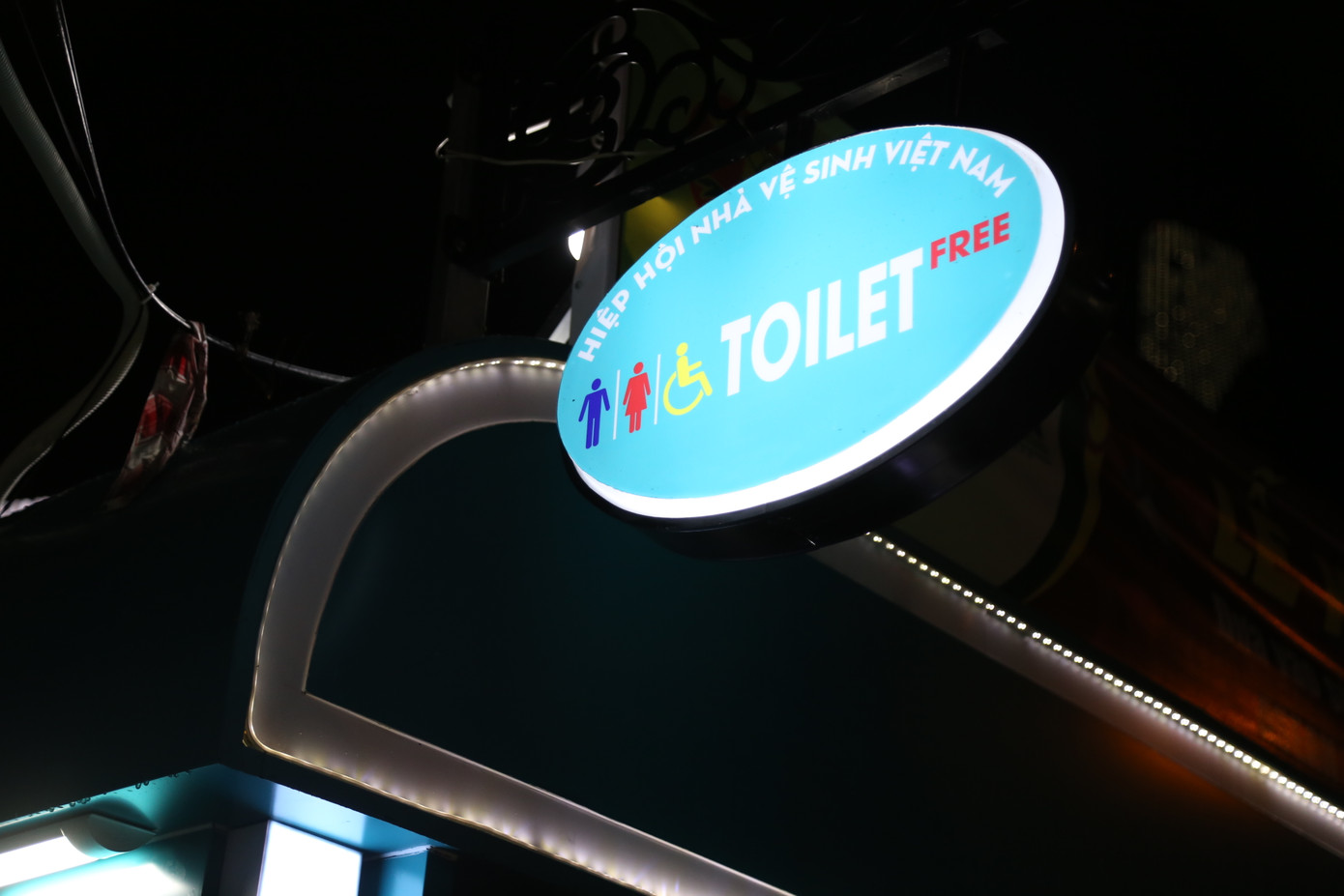 Bảng nhận diện nhà vệ sinh và camera giám sát được lắp đặt bên ngoài nhà vệ sinh.