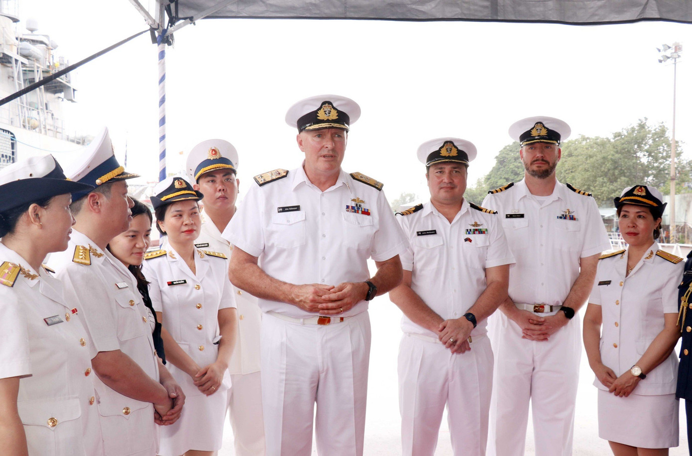 Chuẩn Đô đốc James Gilmmour (thứ tư từ phải qua) trao đổi tại lễ đón. Chuẩn Đô đốc James Gilmmour (thứ tư từ phải qua) trao đổi tại lễ đón.