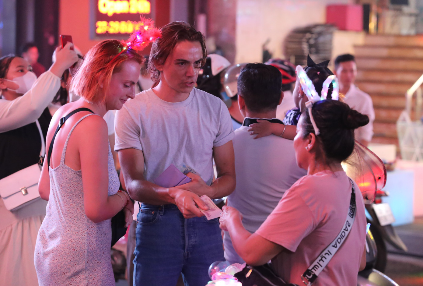 Vị khách Tây chọn mua một chiếc băng đô để tham gia lễ hội.