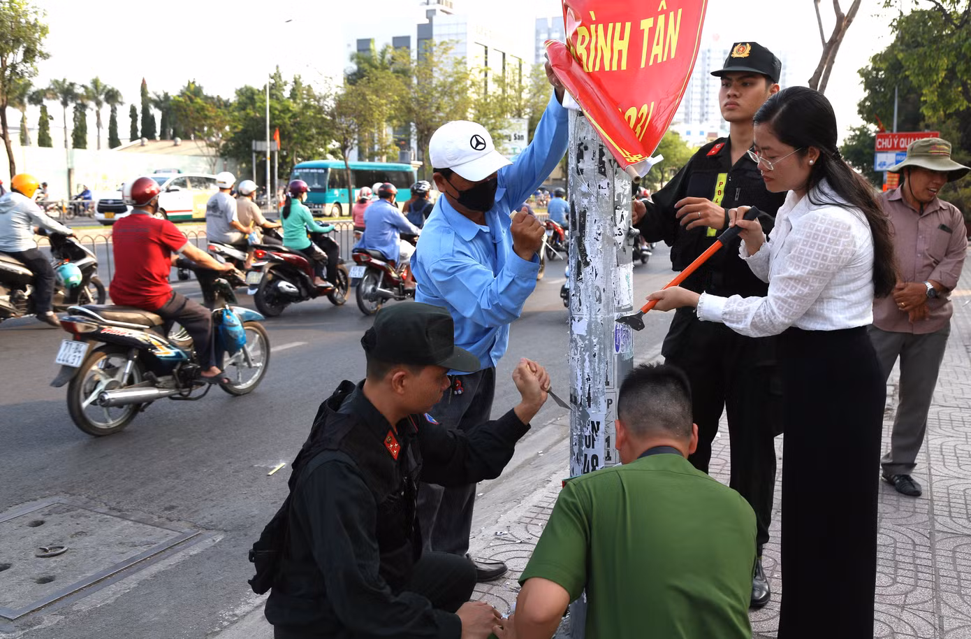 Lãnh đạo quận Bình Tân cùng các chiến sĩ bóc gỡ những thông tin quảng cáo sai quy định.