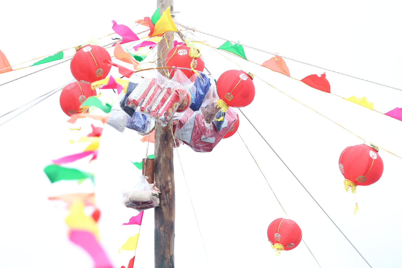 Trên đỉnh cột, ban tổ chức treo nhiều vật phẩm và trang trí đèn lồng, cờ xí rực rỡ tạo thêm phần bắt mắt.