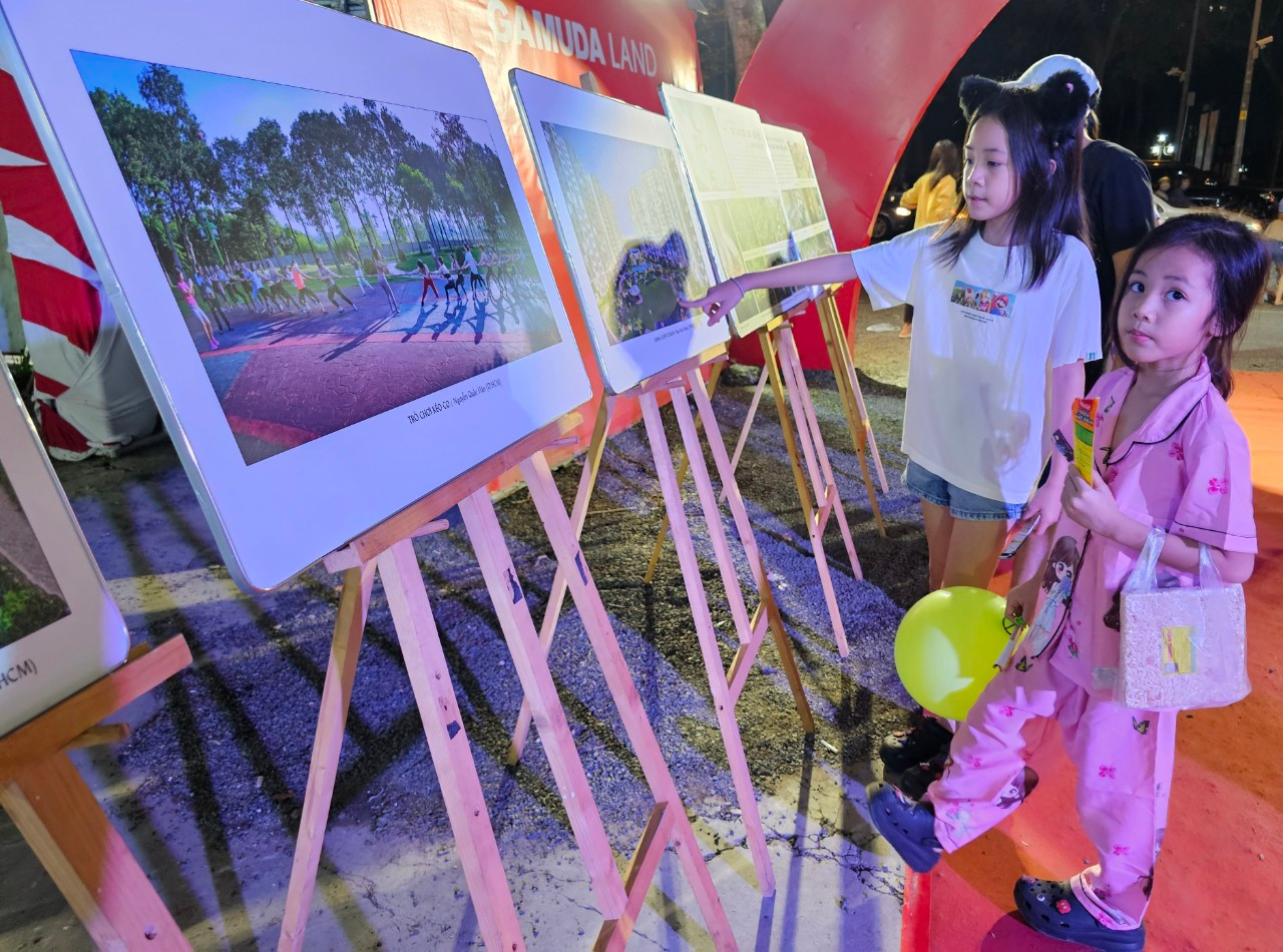 Các em nhỏ tham quan triển lãm các tác phẩm ảnh nghệ thuật về quận Tân Phú. Ảnh: Ngô Tùng