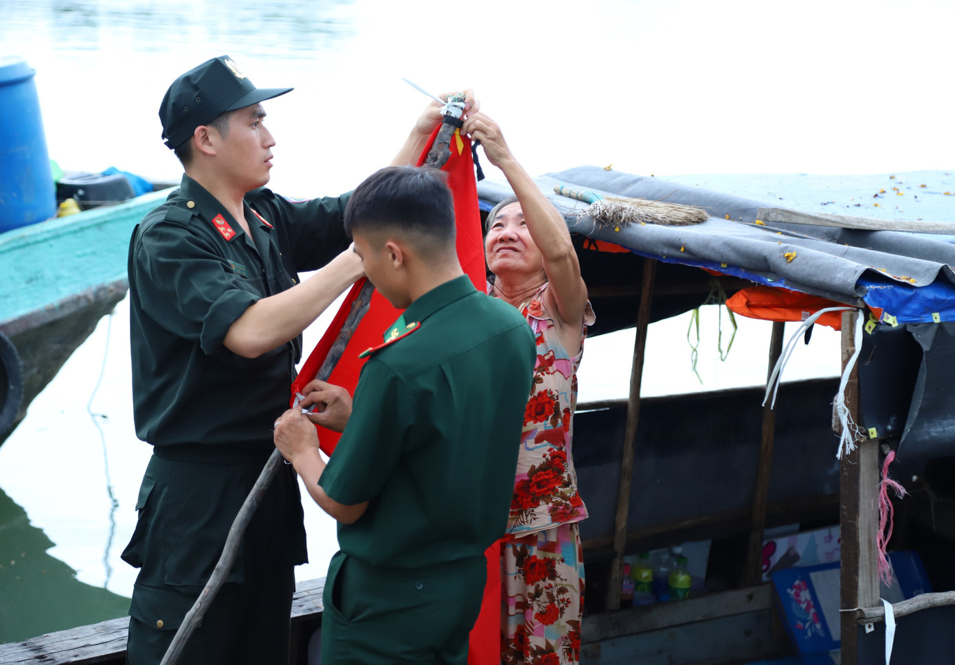 Chiến sĩ Bộ đội biên phòng gửi tặng lá cờ Tổ quốc cho bà con trên đảo.