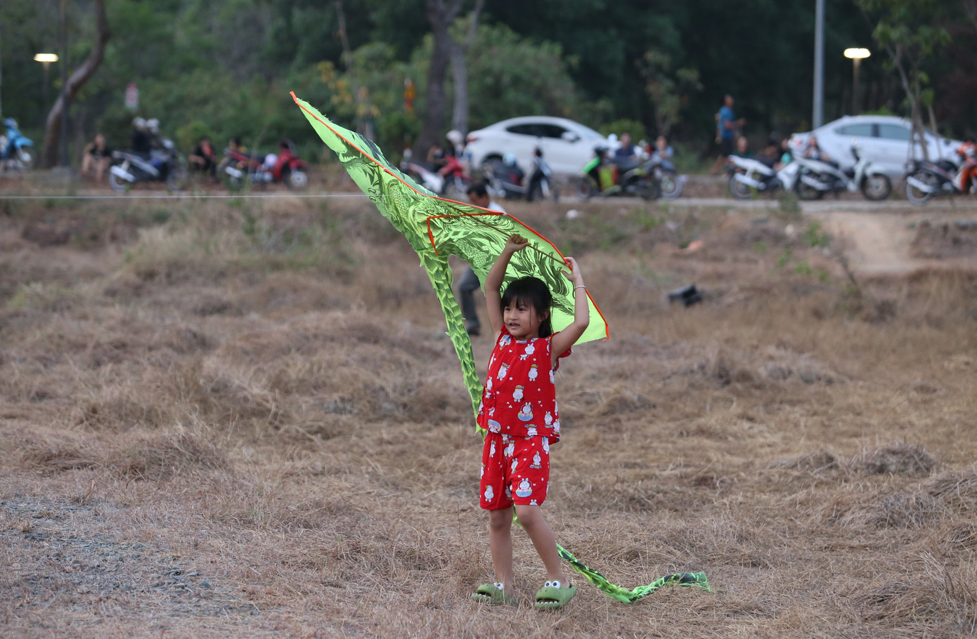 Em bé thích thú đưa cánh diều chuẩn bị bay lên.