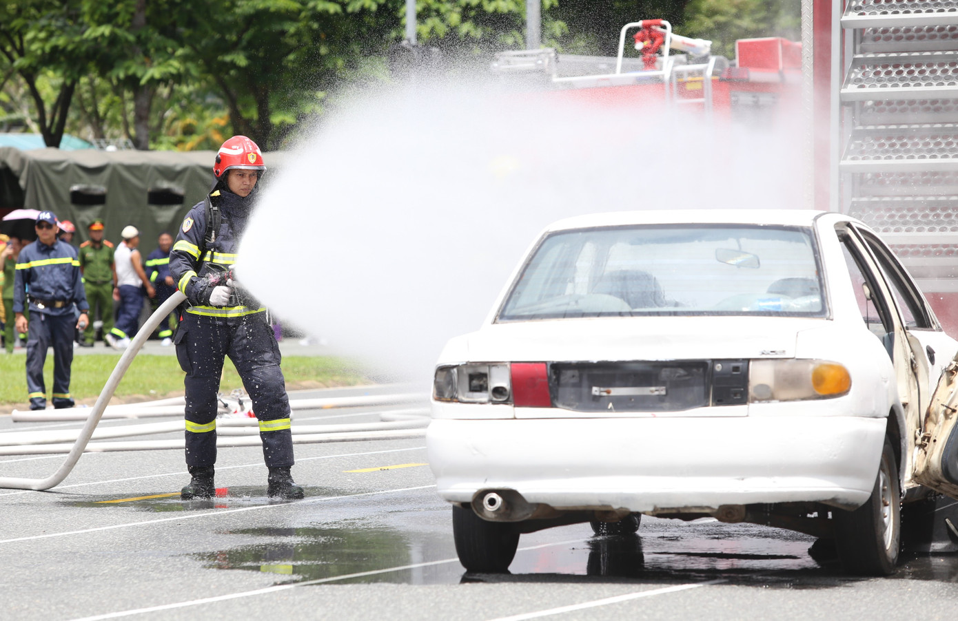Chiến sĩ phun nước dập tắt đám cháy, khói phát ra từ vụ tai nạn.