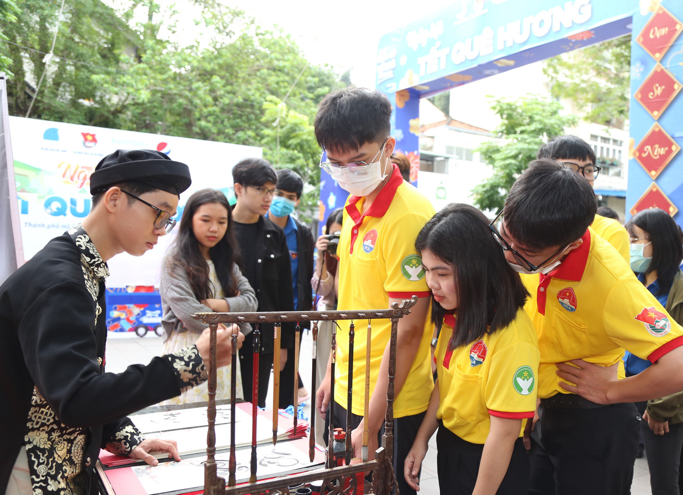 Các bạn sinh viên nhận chữ từ ông đồ trẻ tại chương trình.