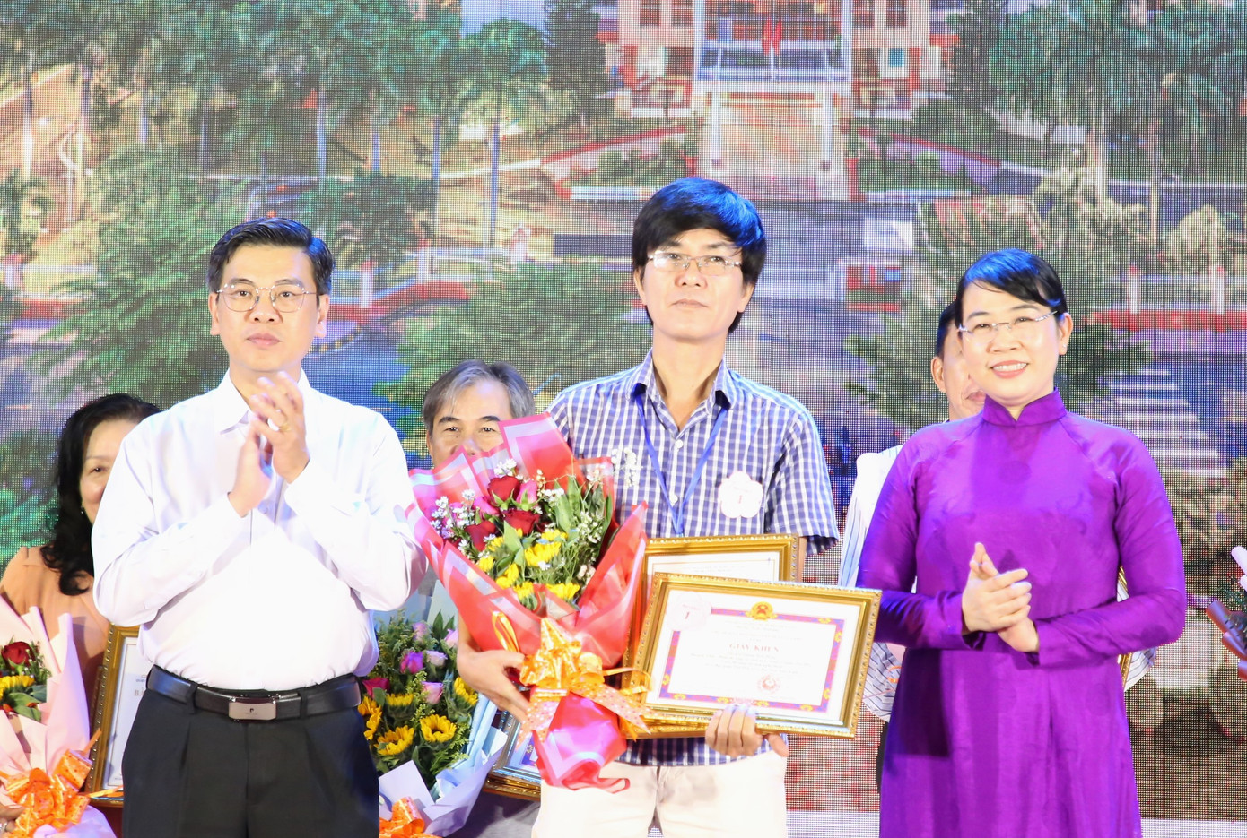 Phó Chủ tịch HĐND TPHCM Nguyễn Văn Dũng (trái) cùng Bí thư Quận ủy Tân Phú Lê Thị Kim Hồng trao giải thưởng cho tác giả đạt giải cao hội thi sáng tác ảnh nghệ thuật về quận.