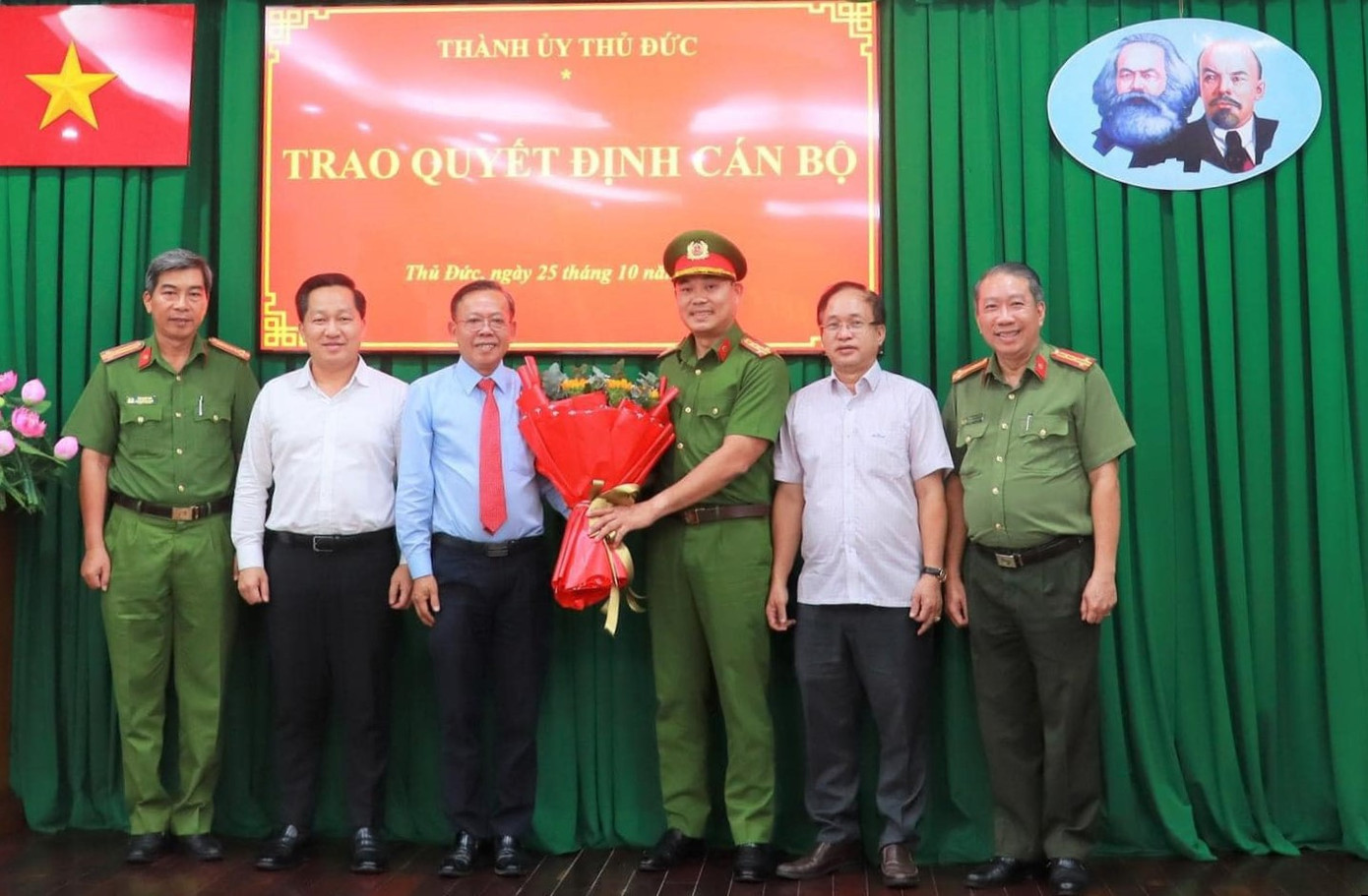 Bí thư Thành uỷ Thủ Đức Nguyễn Hữu Hiệp (thứ ba từ trái qua) trao hoa chúc mừng Đại tá Trần Văn Hiếu. Ảnh: Lương Hợp.