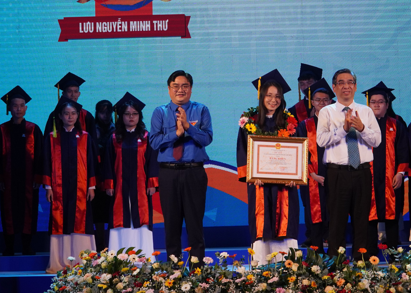 Ông Nguyễn Phước Lộc - Phó Bí thư Thành uỷ, Chủ tịch Uỷ ban MTTQ Việt Nam TP. HCM (bên phải) và anh Ngô Minh Hải - Bí thư Thành Đoàn, Chủ tịch Hội LHTN TP. HCM trao Bằng khen cho thủ khoa được vinh danh.