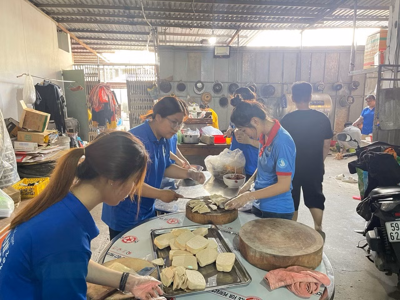 Nguyễn Thị Kiều Trang (áo xanh bên phải) cùng các bạn sinh viên trường nấu ăn từ thiện cho một chương trình.