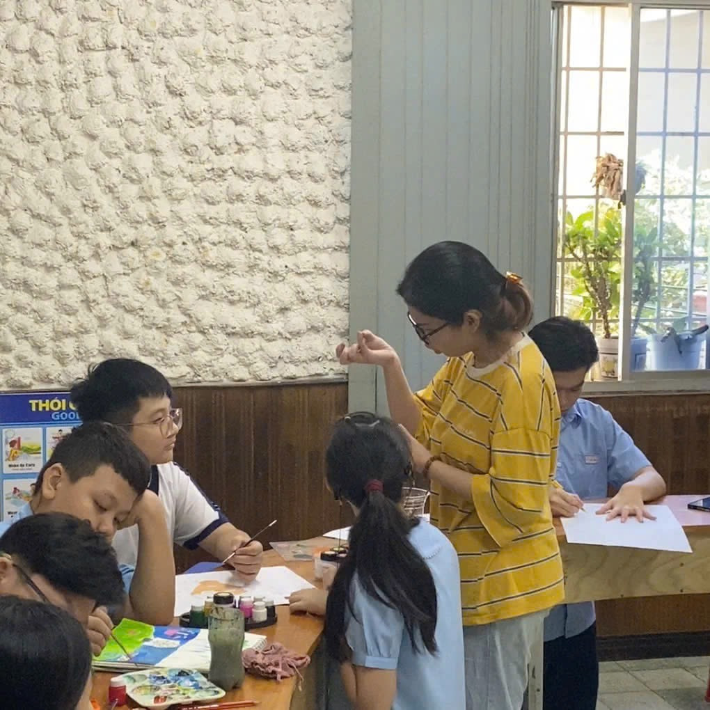 Như Nguyệt (áo vàng) đang đứng lớp dạy vẽ miễn phí cho trẻ. Như Nguyệt (áo vàng) đang đứng lớp dạy vẽ miễn phí cho trẻ.