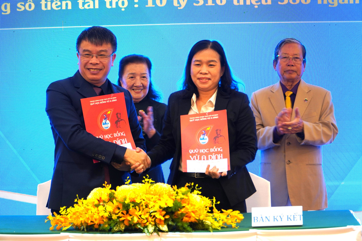 Đại diện trường ĐH Nguyễn Tất Thành (phải) ký kết thỏa thuận hỗ trợ học bổng cho các bạn sinh viên, thông qua Quỹ học bổng Vừ A Dính.