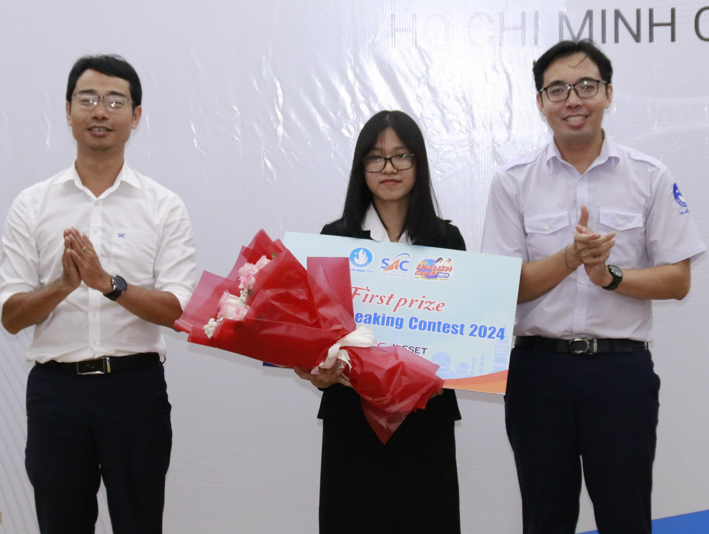 Ban Tổ chức trao giải Nhất cuộc thi 'Hùng biện tiếng Anh' cho thí sinh Lương Thị Thu Ngân (trường ĐH Sư phạm TP. HCM).