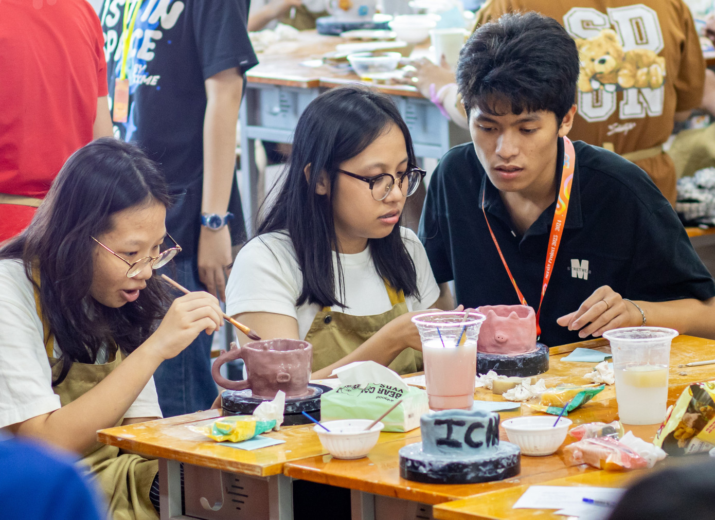 Các bạn trẻ cùng trải nghiệm làm gốm và trang trí gốm tại sự kiện.