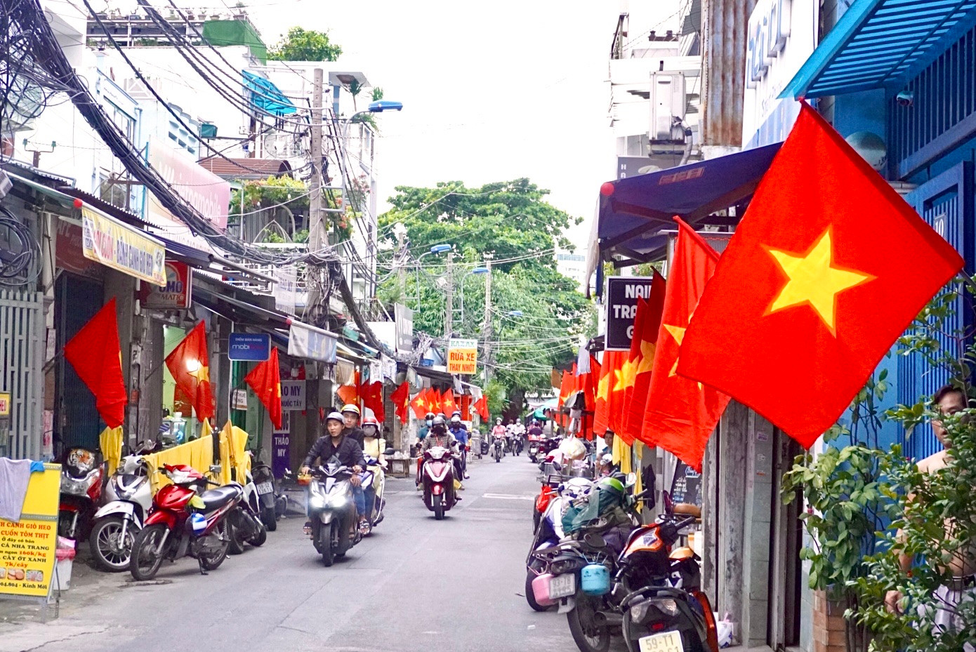 Người dân tại đường Nguyễn Xuân Ôn (Q. Bình Thạnh) đồng loạt treo cờ Tổ quốc.