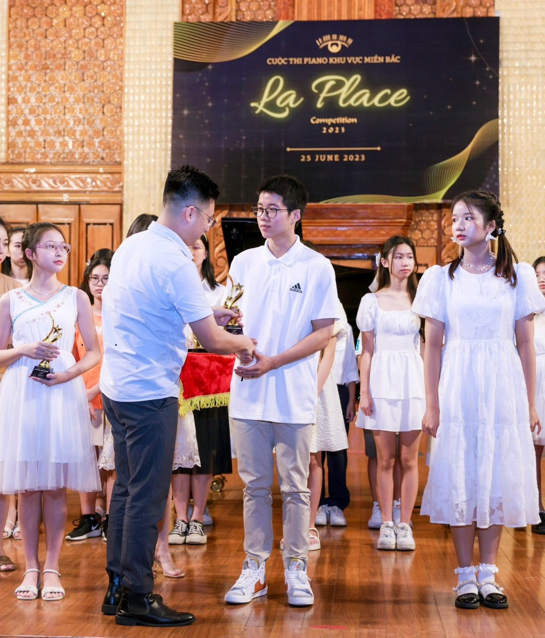 Sĩ Tiến nhận giải thưởng trong cuộc thi về piano.