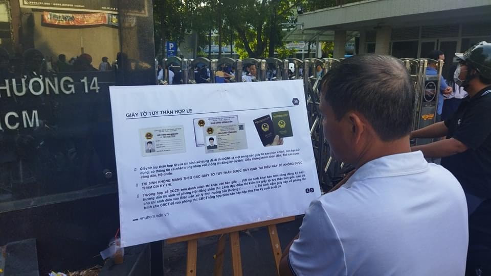 Phụ huynh đọc quy định về giấy tờ tùy thân hợp lệ. (Ảnh: ĐHQG TP. HCM)