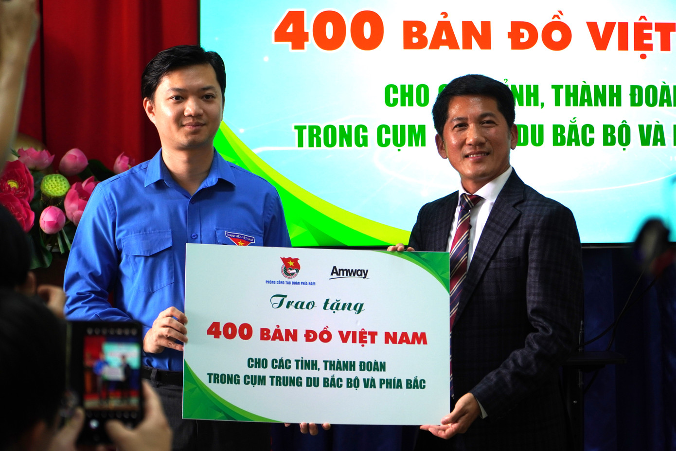 Anh Nguyễn Minh Triết - Bí thư T.Ư Đoàn, Chủ tịch Hội Sinh viên Việt Nam (bên trái) nhận bảng trao tặng 400 tấm bản đồ Việt Nam từ ông Huỳnh Thiên Triều – Tổng Giám đốc Amway Việt Nam.