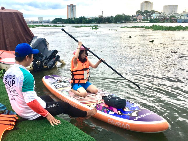 Một bạn trẻ được huấn luyện viên hướng dẫn trước khi tham gia chèo SUP. Một bạn trẻ được huấn luyện viên hướng dẫn trước khi tham gia chèo SUP.