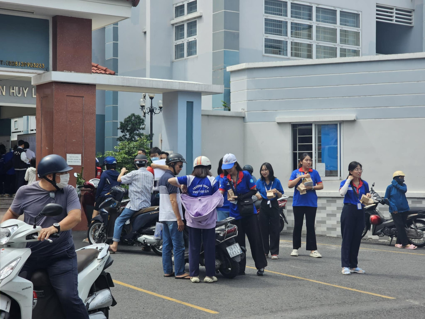 Không khí trước buổi thi rộn ràng với hình ảnh phụ huynh tay trong tay với các thí sinh đến điểm thi làm thủ tục.