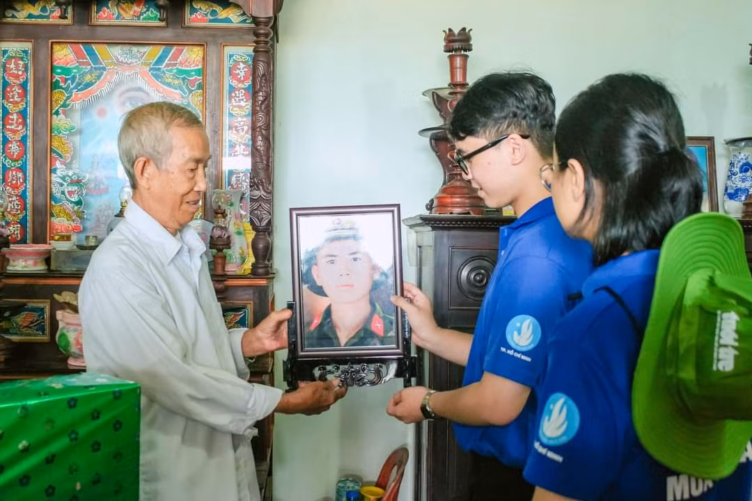 Chị Trần Thu Hà cùng đoàn công tác trao di ảnh liệt sĩ phục hồi cho gia đình. (Ảnh: Hội Sinh viên TP. HCM)
