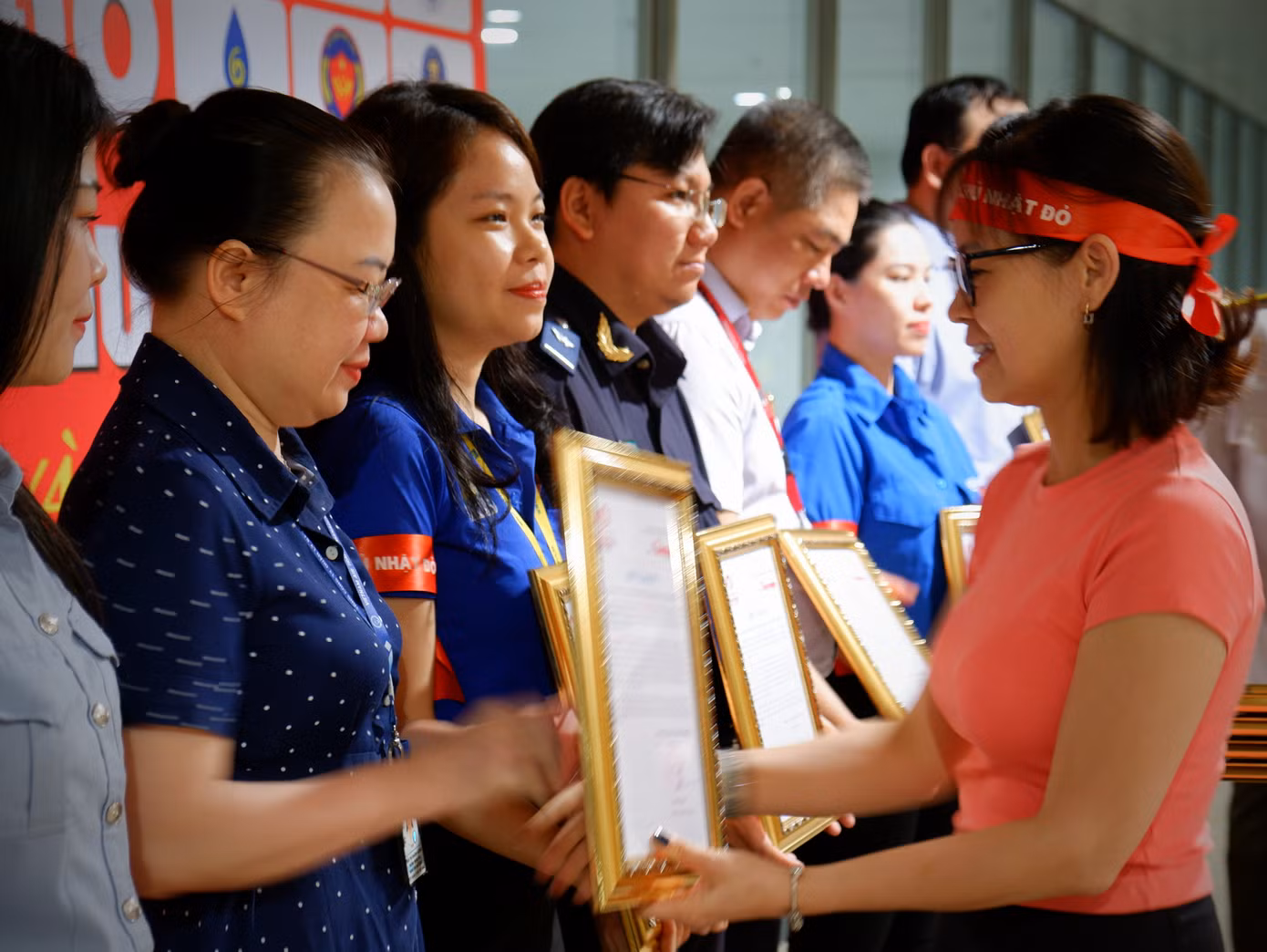 Chị Đặng Thụy Đông Nghi trao thư cảm ơn của báo Tiền Phong cho các đơn vị đã đồng hành cùng chương trình 'Chủ nhật Đỏ'.