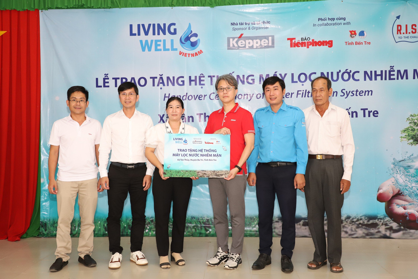 Ông Wong Wai Foo - Giám đốc Bộ phận Tái tạo đô thị bền vững, Khối Bất động sản, Tập đoàn Keppel tại Việt Nam (thứ ba, từ phải sang) trao bảng tượng trưng hệ thống máy lọc nước sạch cho xã Tân Thủy, huyện Ba Tri, tỉnh Bến Tre. (Ảnh: Ngô Tùng)