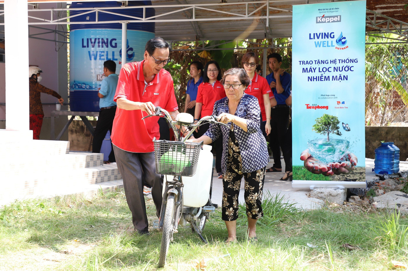 Tình nguyện viên của chương trình hỗ trợ người dân xã Tân Thủy đưa nước lên xe.
