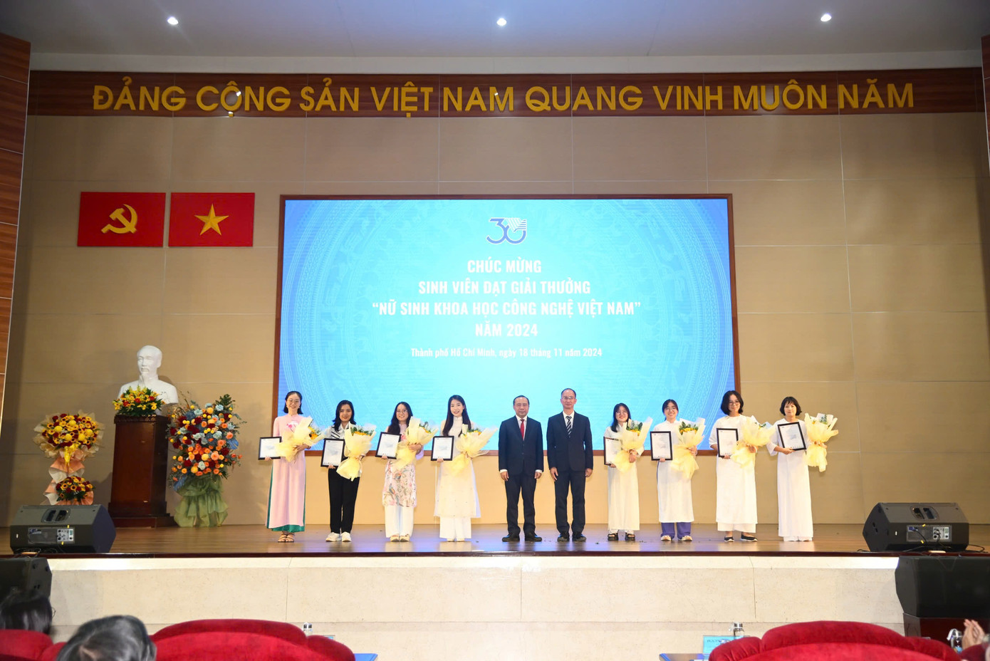 PGS. TS Vũ Hải Quân và PGS. TS Trần Cao Vinh tặng hoa và thư chúc mừng cho 11 nữ sinh đạt Giải thưởng Sinh viên khoa học - công nghệ Việt Nam năm 2024.