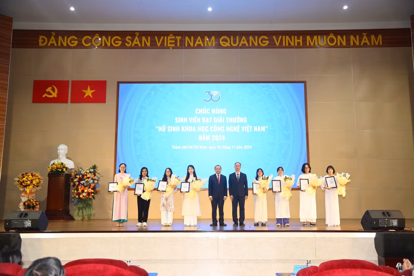 PGS. TS Vũ Hải Quân và PGS. TS Trần Cao Vinh tặng hoa và thư chúc mừng cho 11 nữ sinh đạt Giải thưởng Sinh viên khoa học - công nghệ Việt Nam năm 2024.
