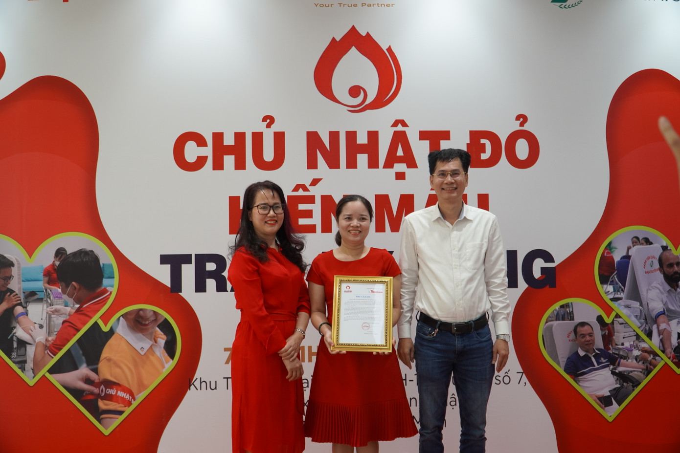 Bà Nguyễn Thị Ánh Ngọc - Phó Tổng Giám đốc công ty ACC, đại diện Tập đoàn Nguyên liệu Á Châu AIG và Nhà báo Lý Thành Tâm trao thư cảm ơn tới đại diện Hội Chữ thập đỏ phường Tân Thuận Đông (Q. 7, TP. HCM).