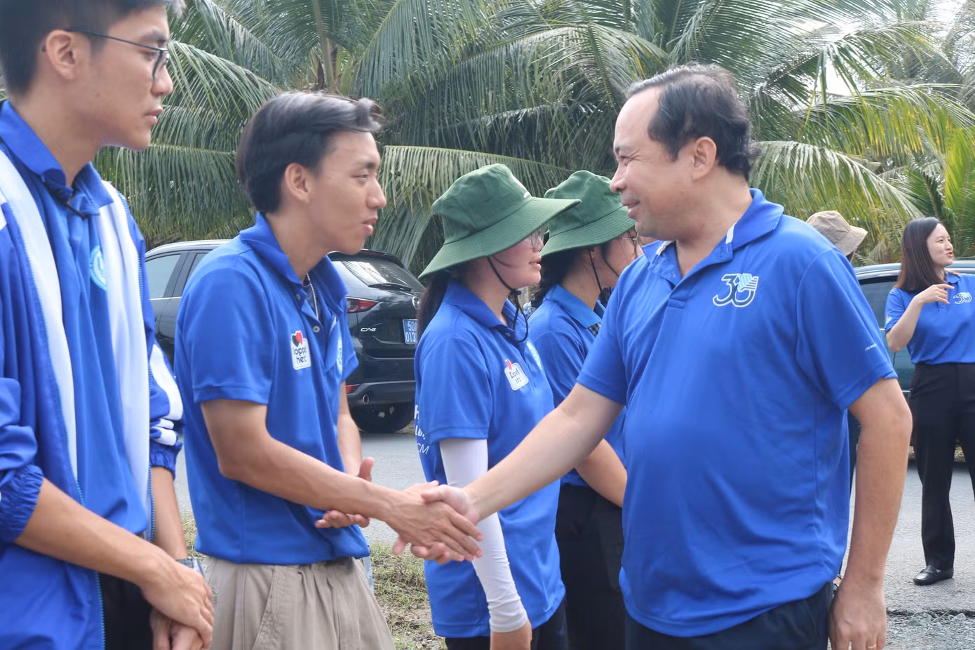 PGS. TS Vũ Hải Quân bắt tay động viên từng sinh viên tình nguyện. (Ảnh: ĐHQG TP. HCM)
