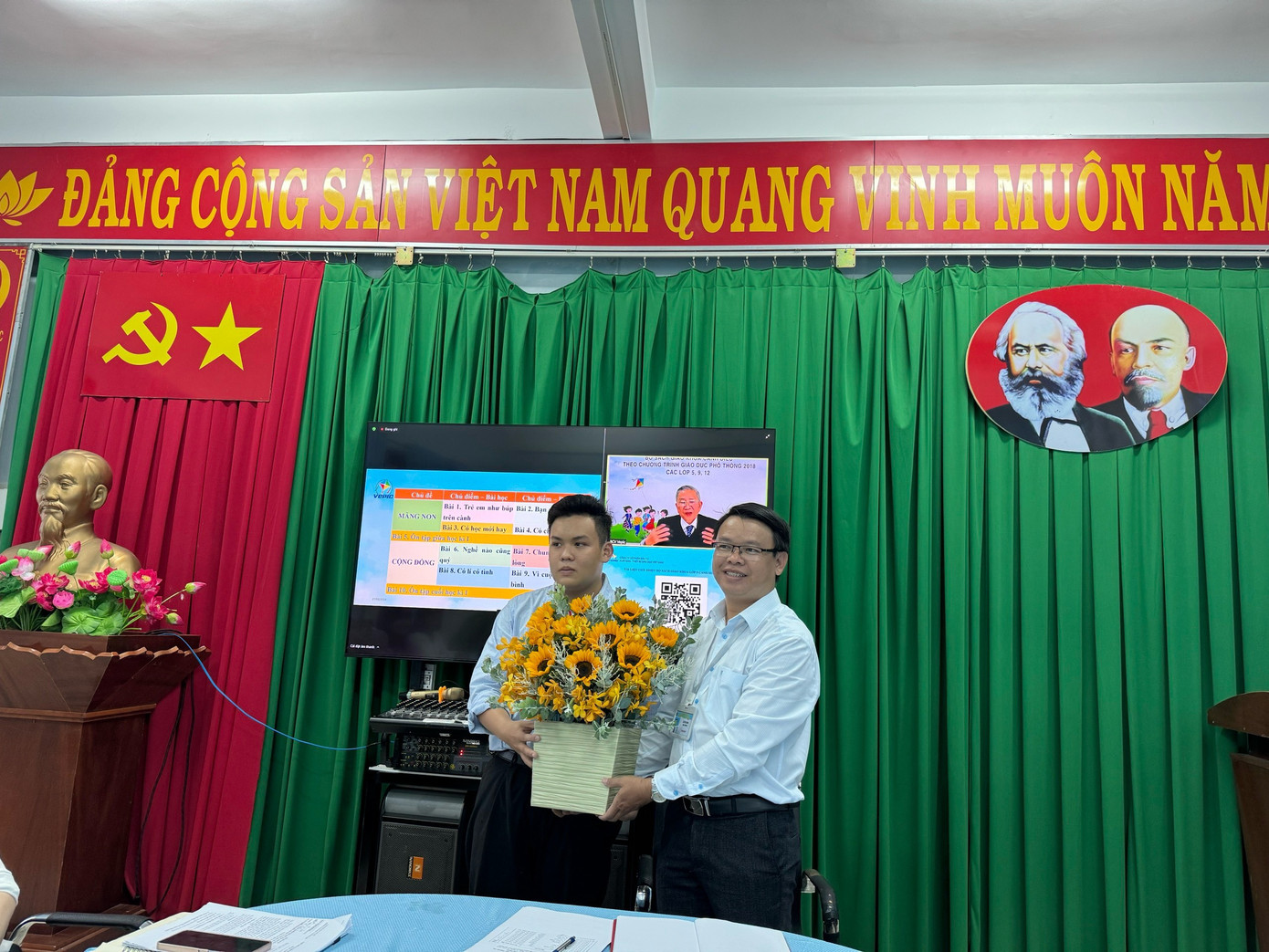 Thiên Bảo (trái) đại diện đoàn thực tập Sư phạm trao hoa đến thầy Lê Hữu Bình, Hiệu trưởng trường Tiểu học Thạnh An. (Ảnh: NVCC) Thiên Bảo (trái) đại diện đoàn thực tập Sư phạm trao hoa đến thầy Lê Hữu Bình, Hiệu trưởng trường Tiểu học Thạnh An. (Ảnh: NVCC)