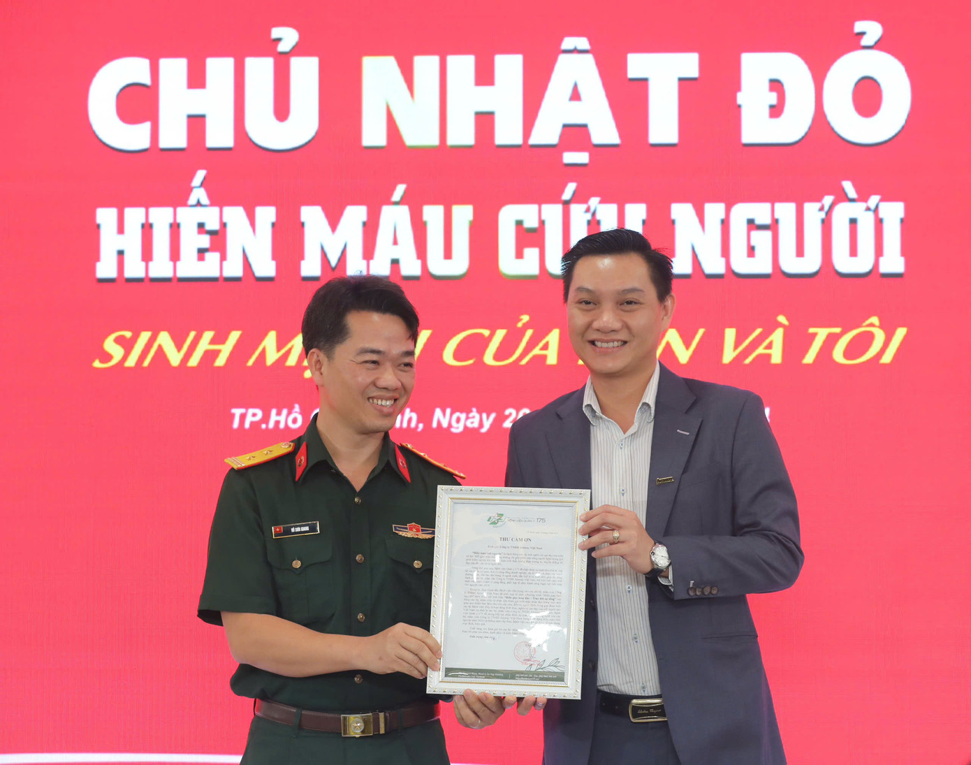 BS Vũ Sơn Giang - Phó Chủ nhiệm Chính trị Bệnh viện Quân y 175 (bên trái) trao thư cảm ơn cho đại diện lãnh đạo Công ty Amway Việt Nam. (Ảnh: Duy Anh)