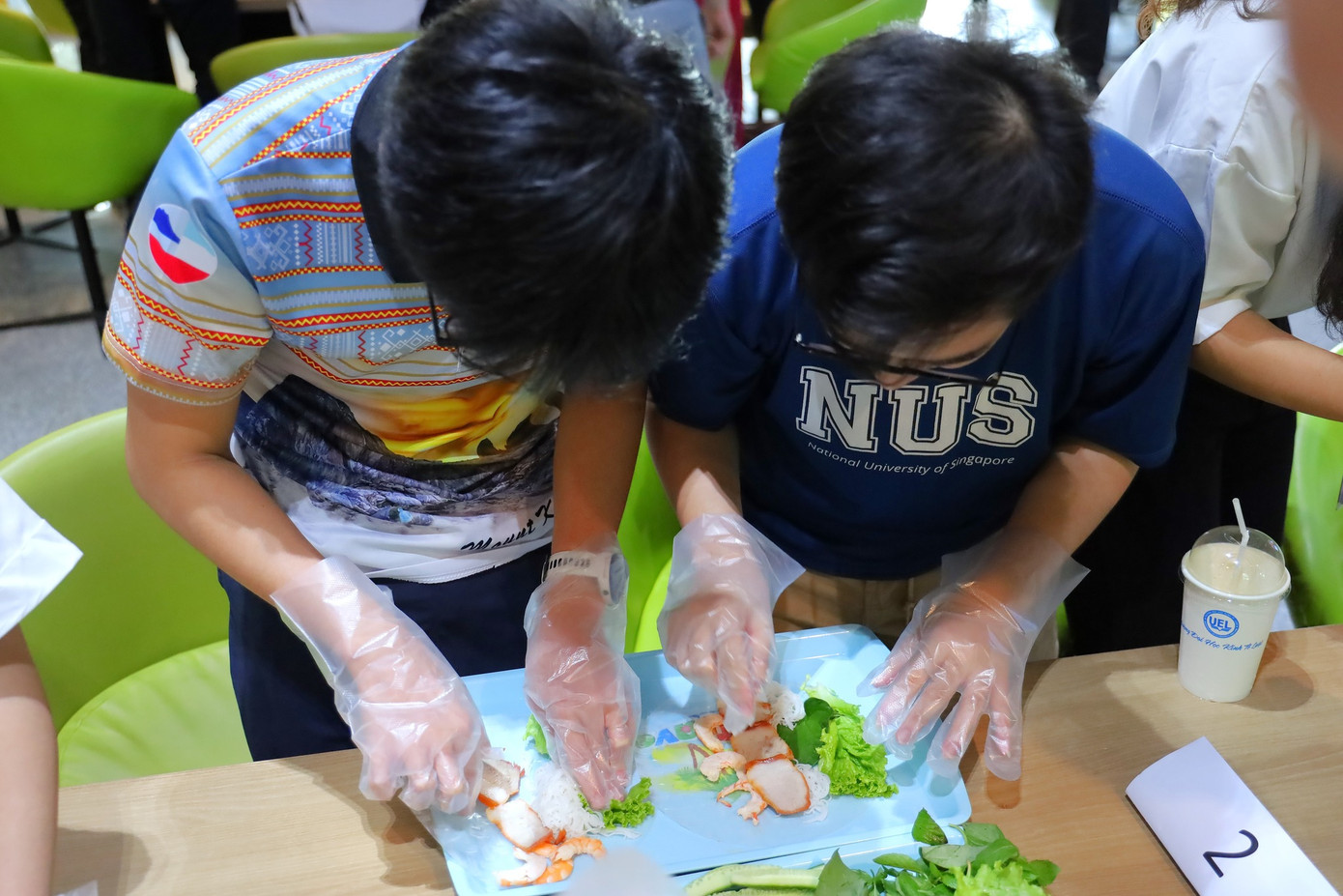 Các bạn sinh viên ĐHQG Singapore thích thú khi tự tay trải nghiệm làm gỏi cuốn.